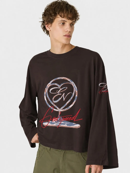 Person wearing a black long-sleeve oversized t-shirt with a logo and text on a white background