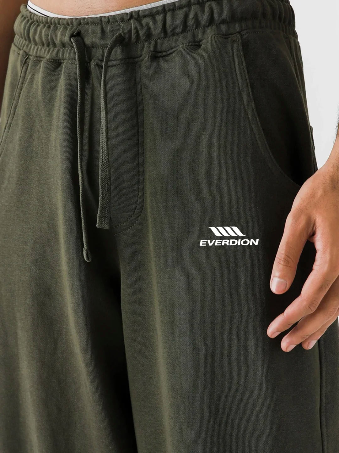 Green sweatpants with a visible brand logo on a neutral background