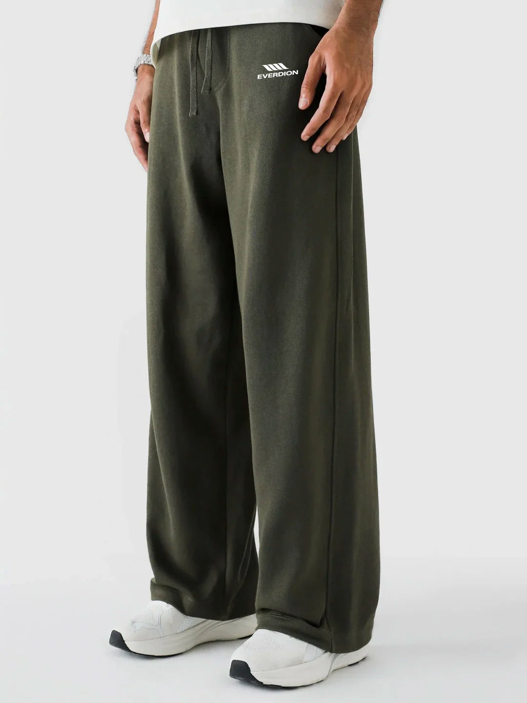 Person wearing olive green pants with a brand logo on a white background