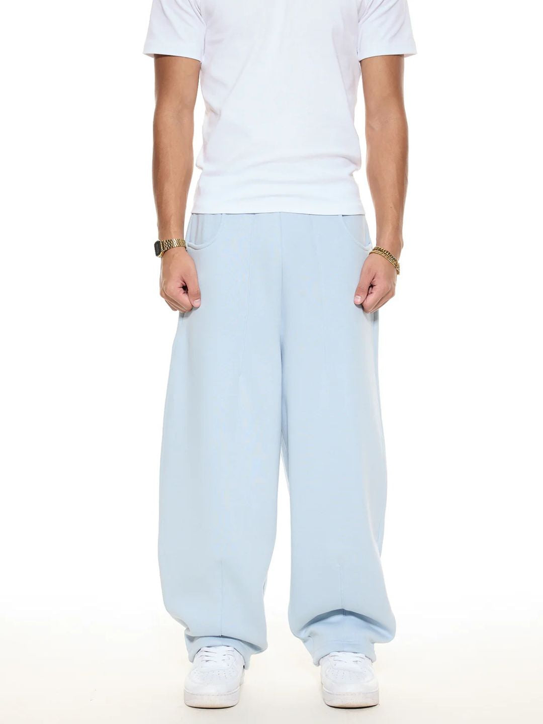 Person wearing light blue sweatpants and a white t-shirt on a white background