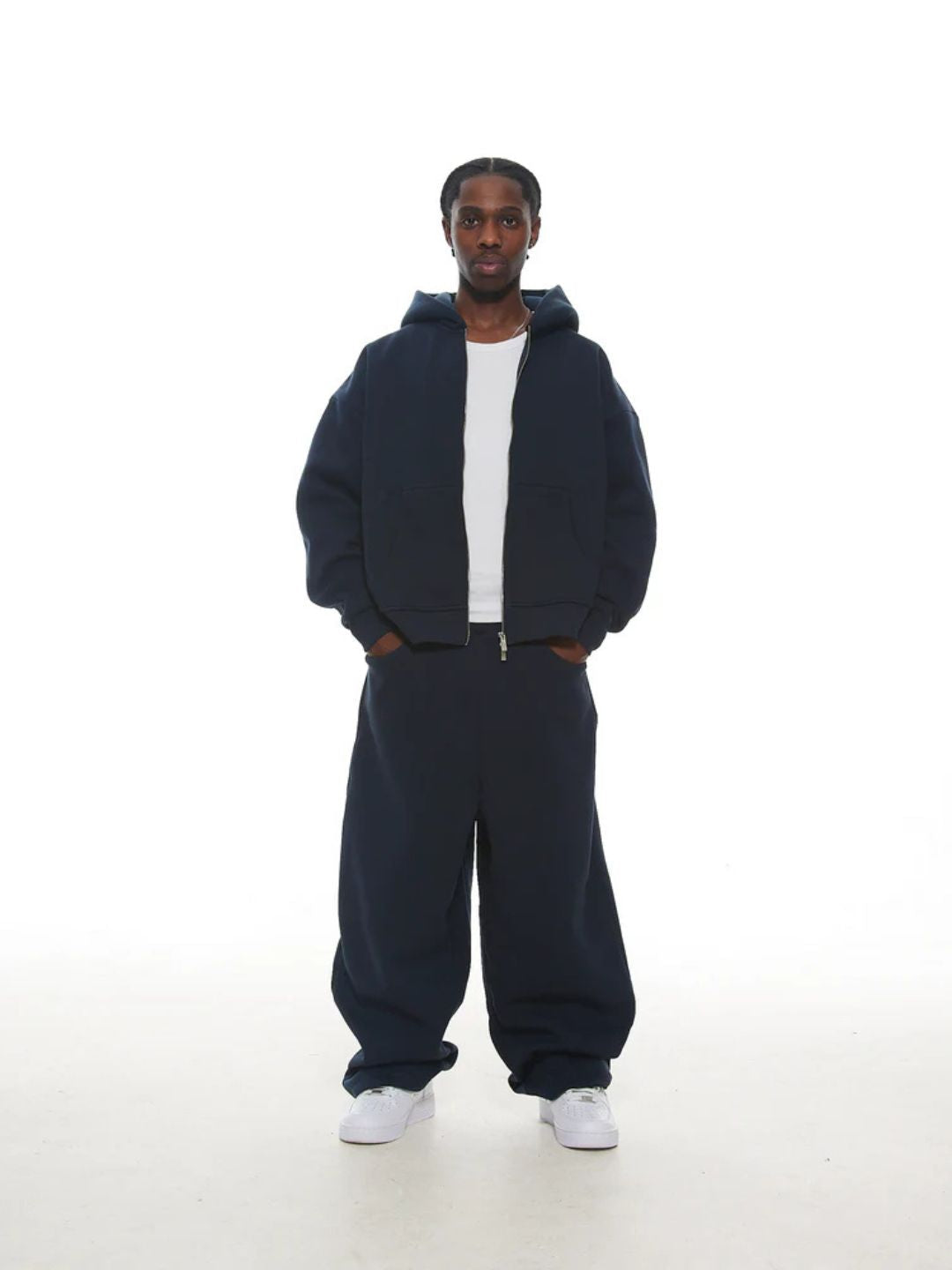 Person wearing a navy blue tracksuit on a white background