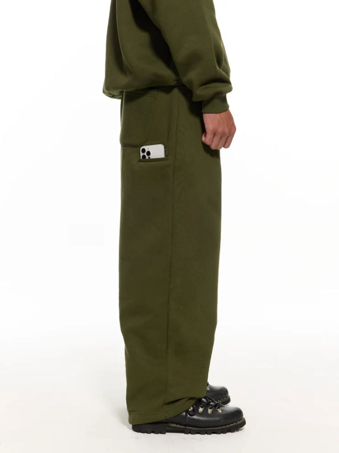 Person wearing olive green sweatpants with white background