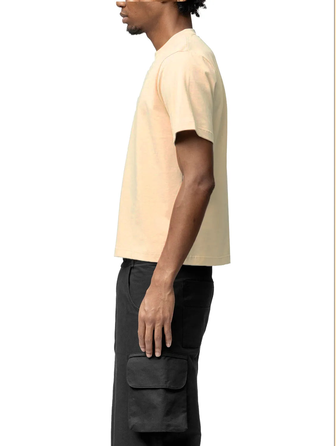 Person wearing a beige t-shirt and black pants on a white background