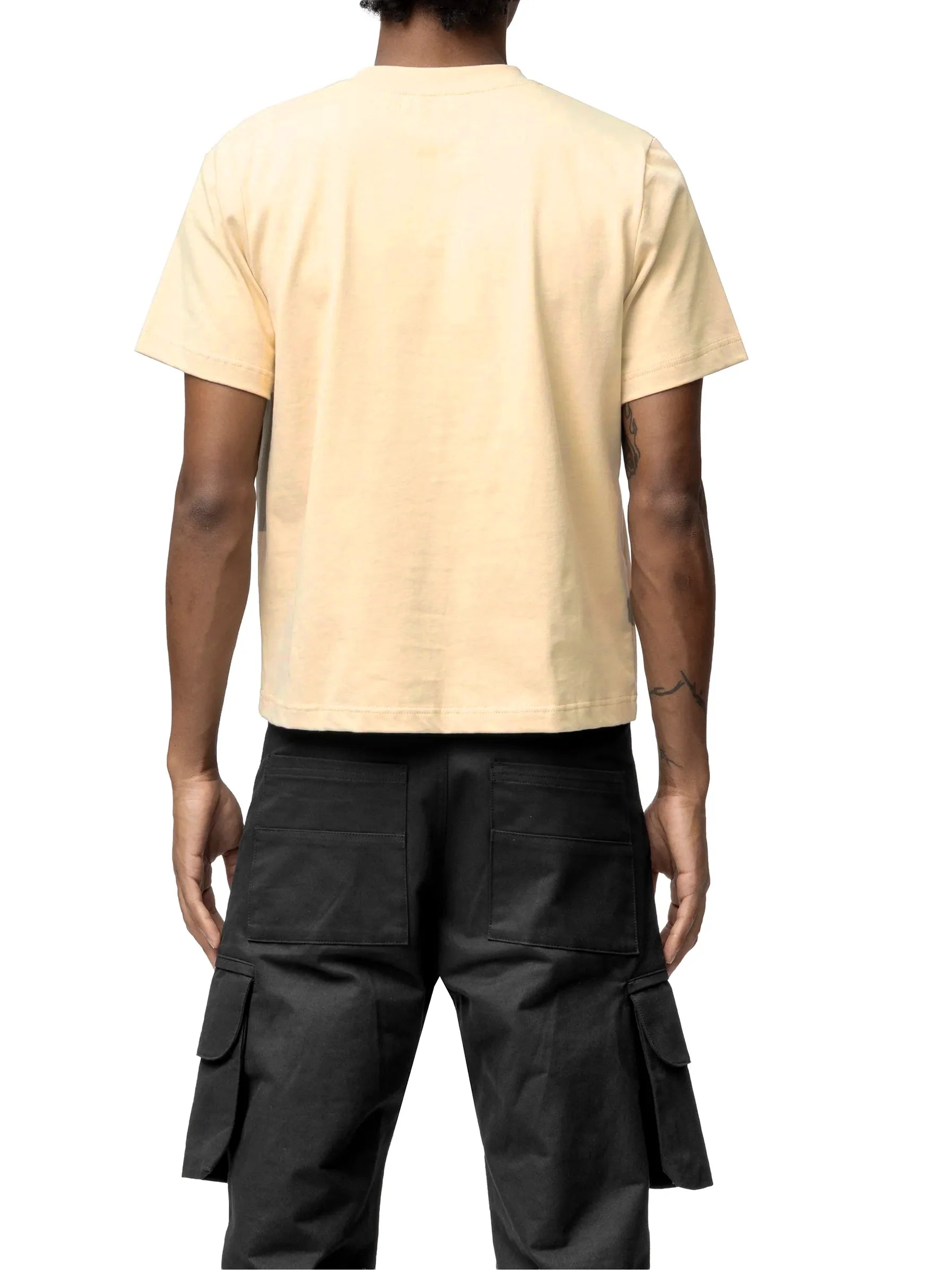 Person wearing a beige t-shirt and black cargo pants on a white background