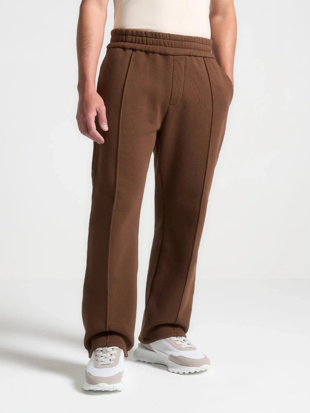 Brown pants worn by a person on a white background