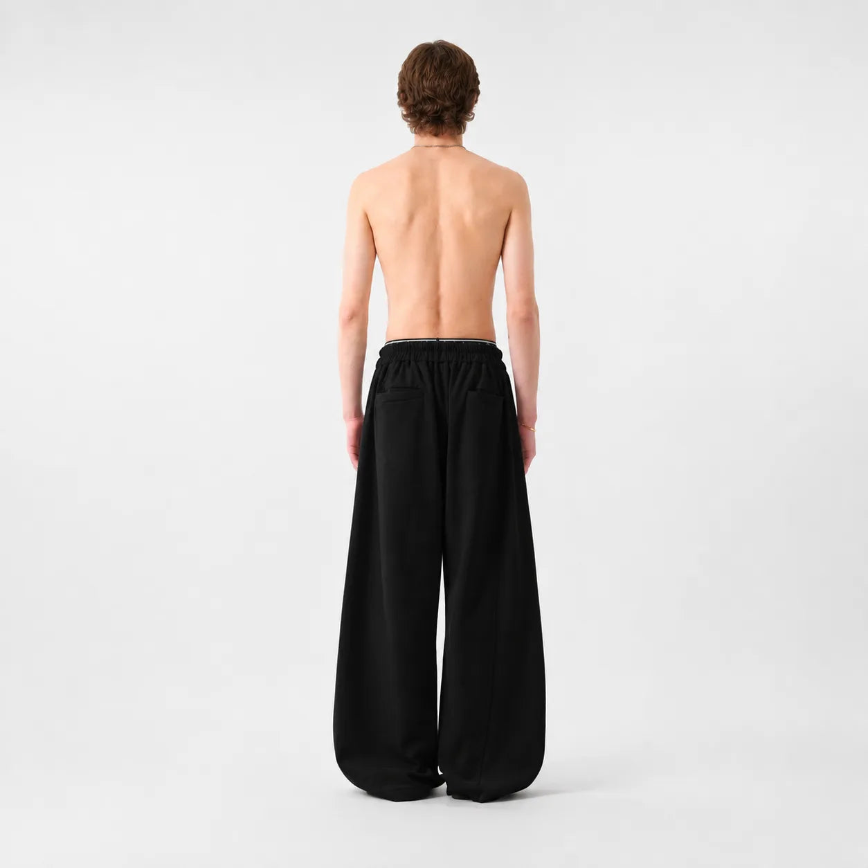 Person wearing black wide-leg sweatpants on a white background