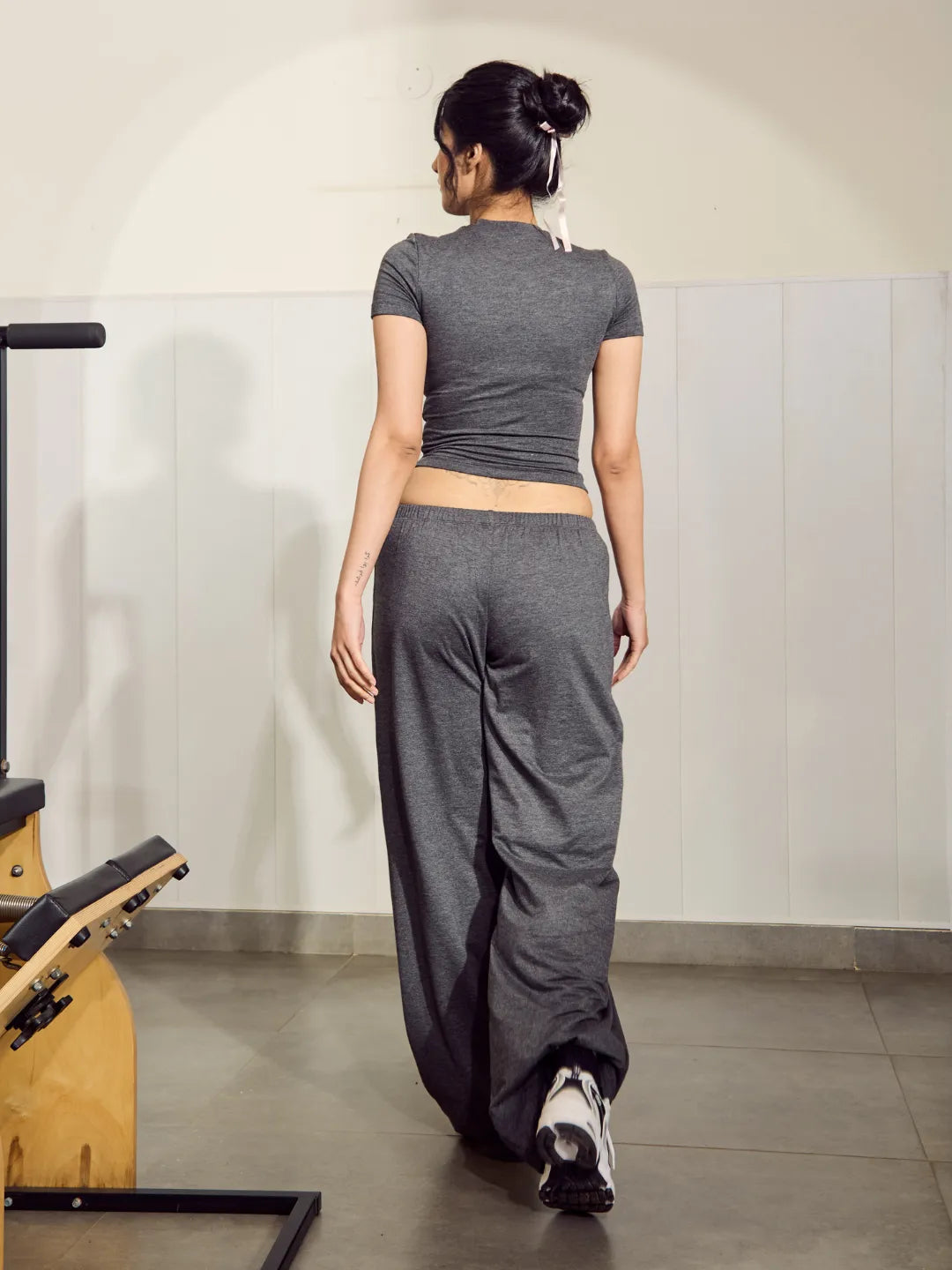 Woman in grey athletic wear walking in a gym setting