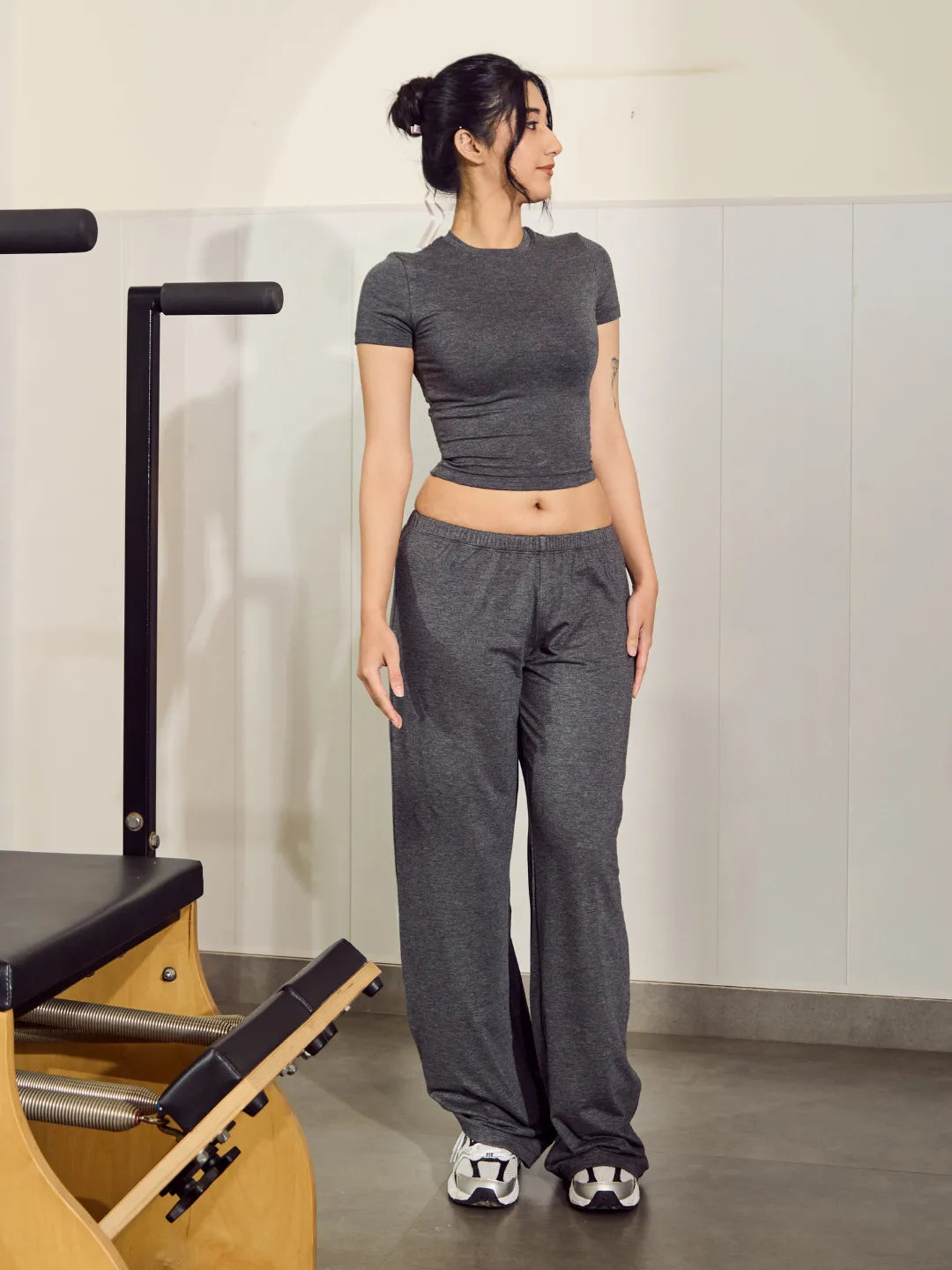 Woman in grey athletic outfit standing in a gym setting