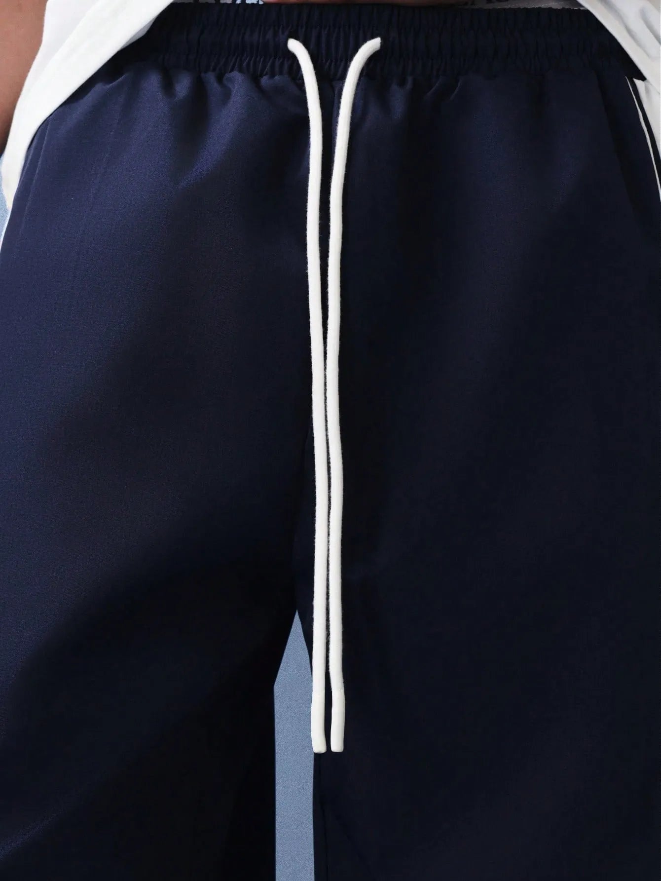 Navy pants with white stripes on a plain background