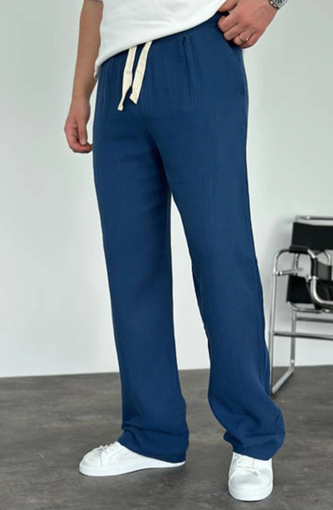 Person wearing blue sweatpants with a white background