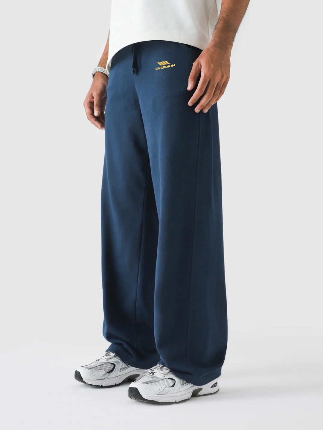 Person wearing navy sweatpants with a brand logo on a white background