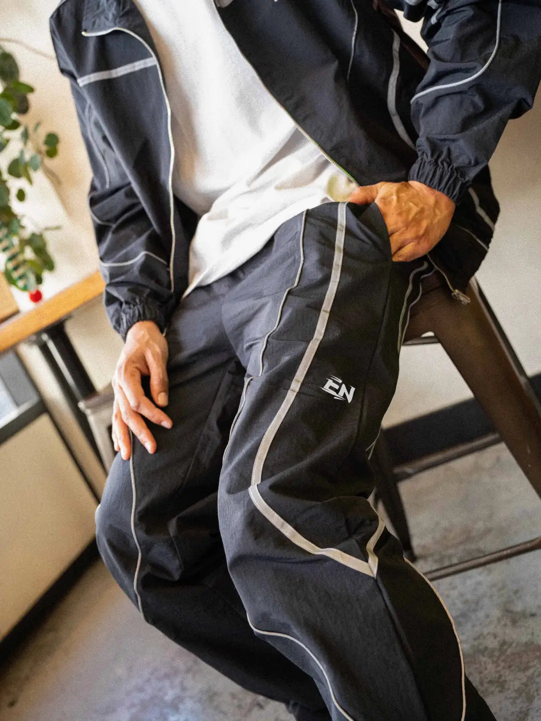 The Black pant delivers a structured yet lightweight feel, while the relaxed-fit track pants ensure fluid movement and all-day comfort. 
