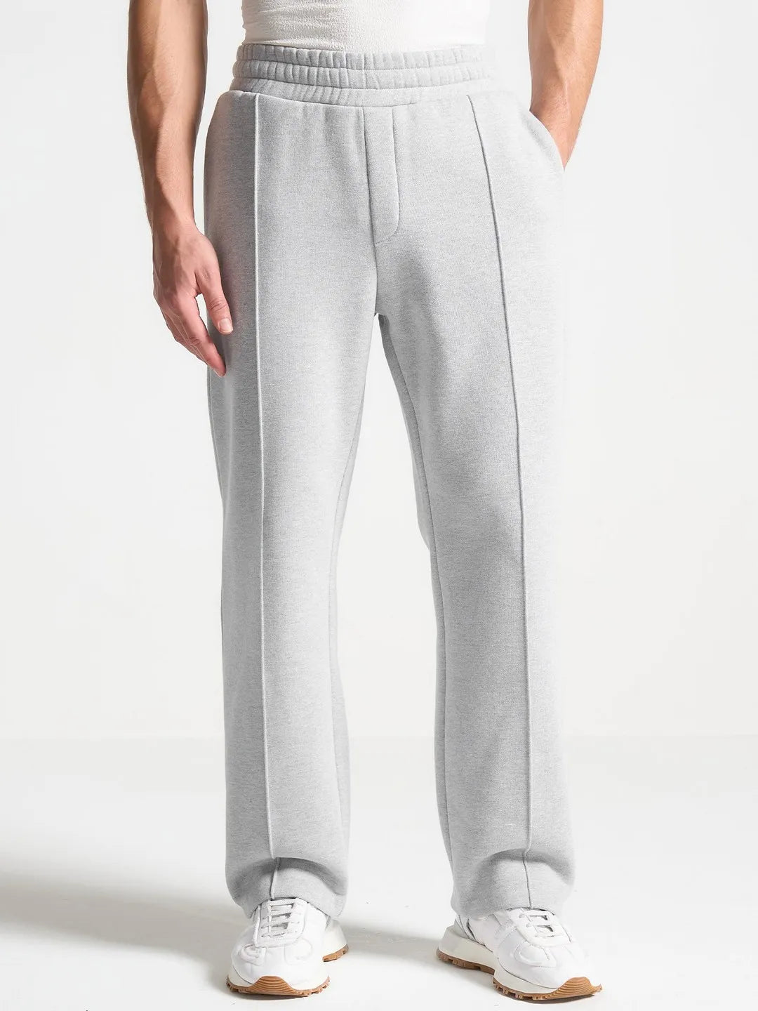 Person wearing light gray sweatpants on a white background