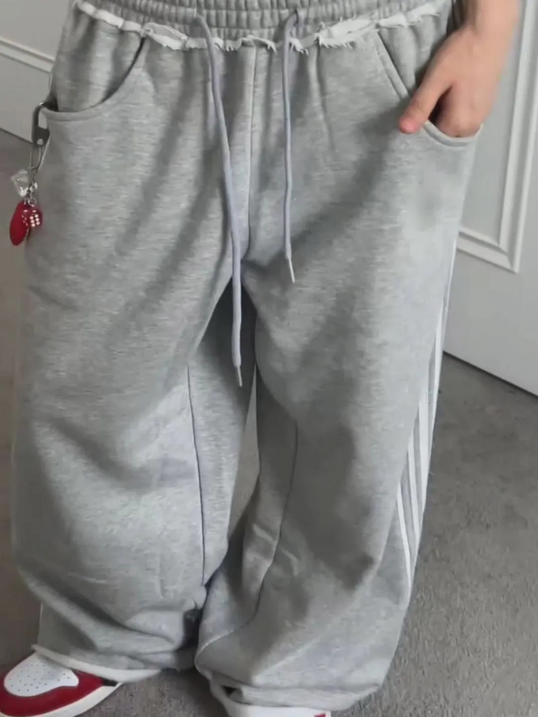 Grey sweatpants worn by a person on a neutral background