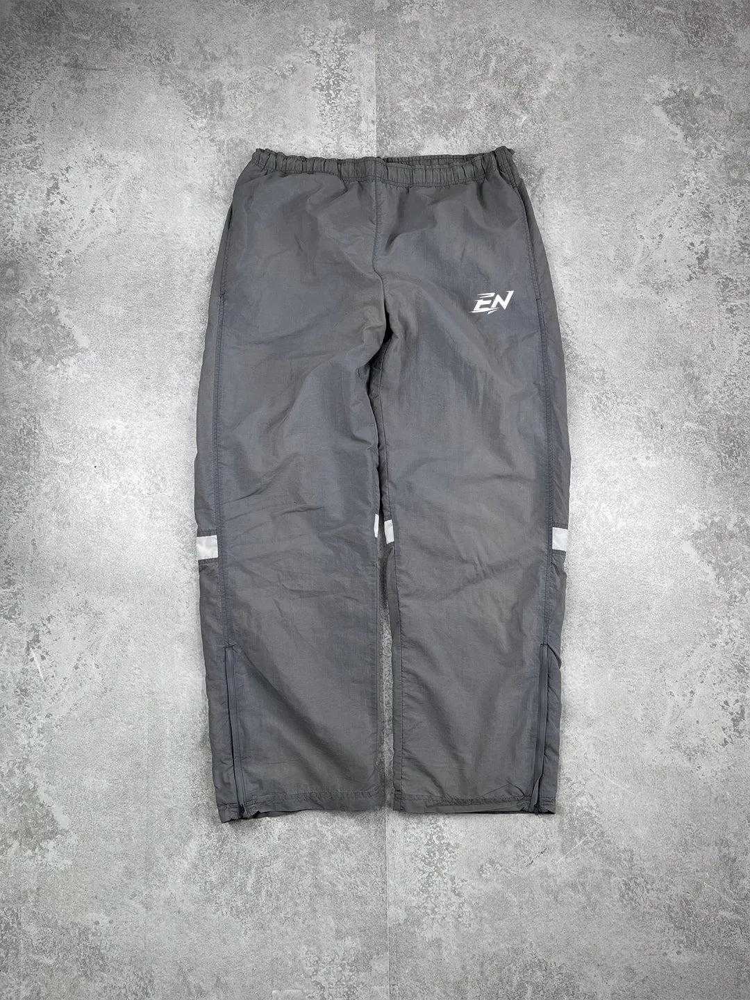 Grey pants with a logo on a grey concrete surface