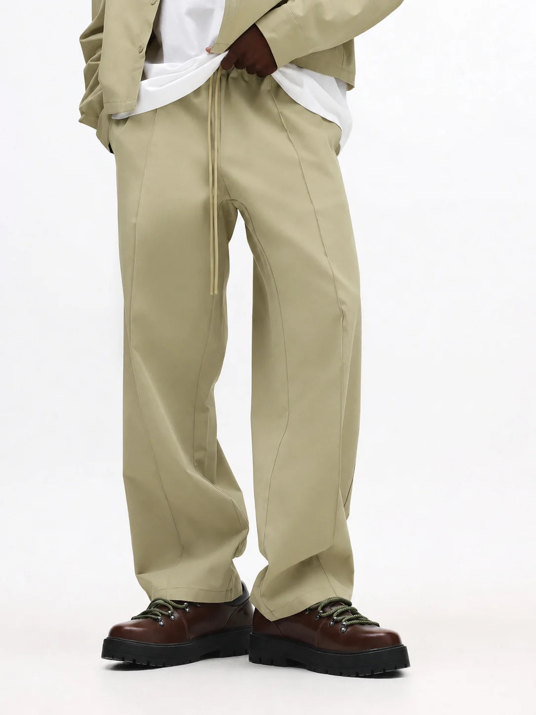 Beige pants worn by a person on a white background