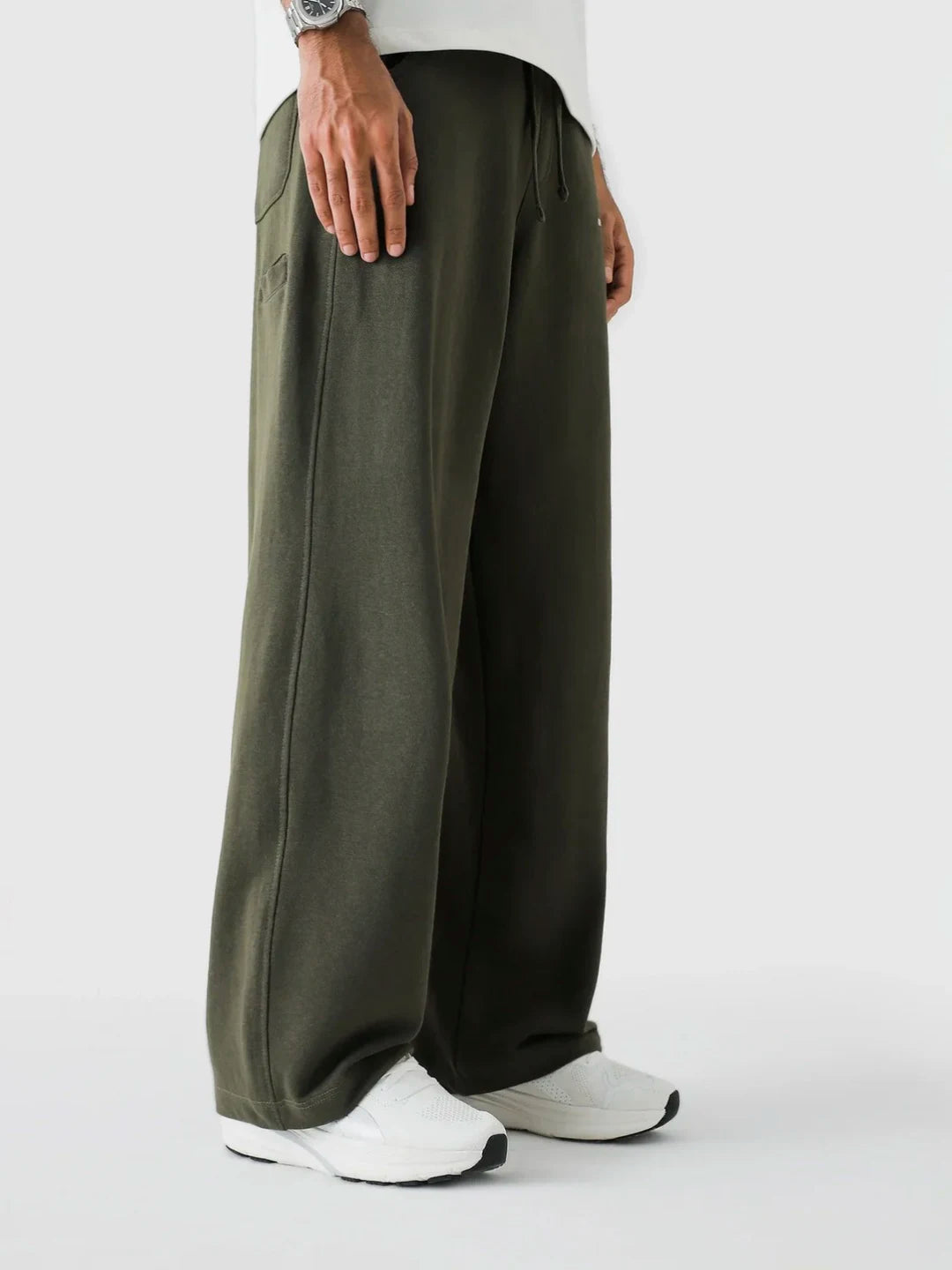 Person wearing olive green wide-leg pants on a white background