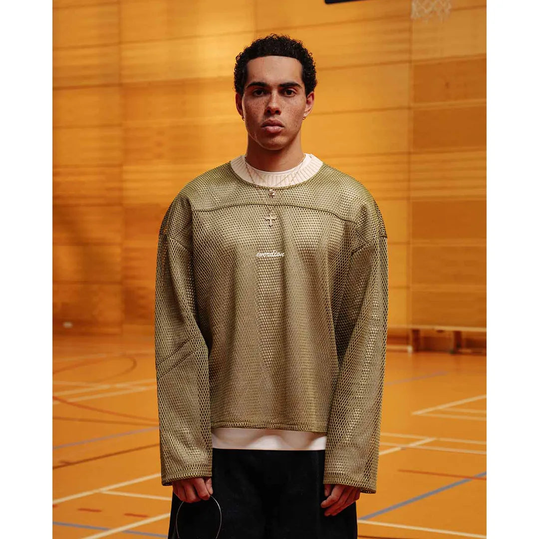 Person wearing a green textured shirt with a white collar on a basketball court.