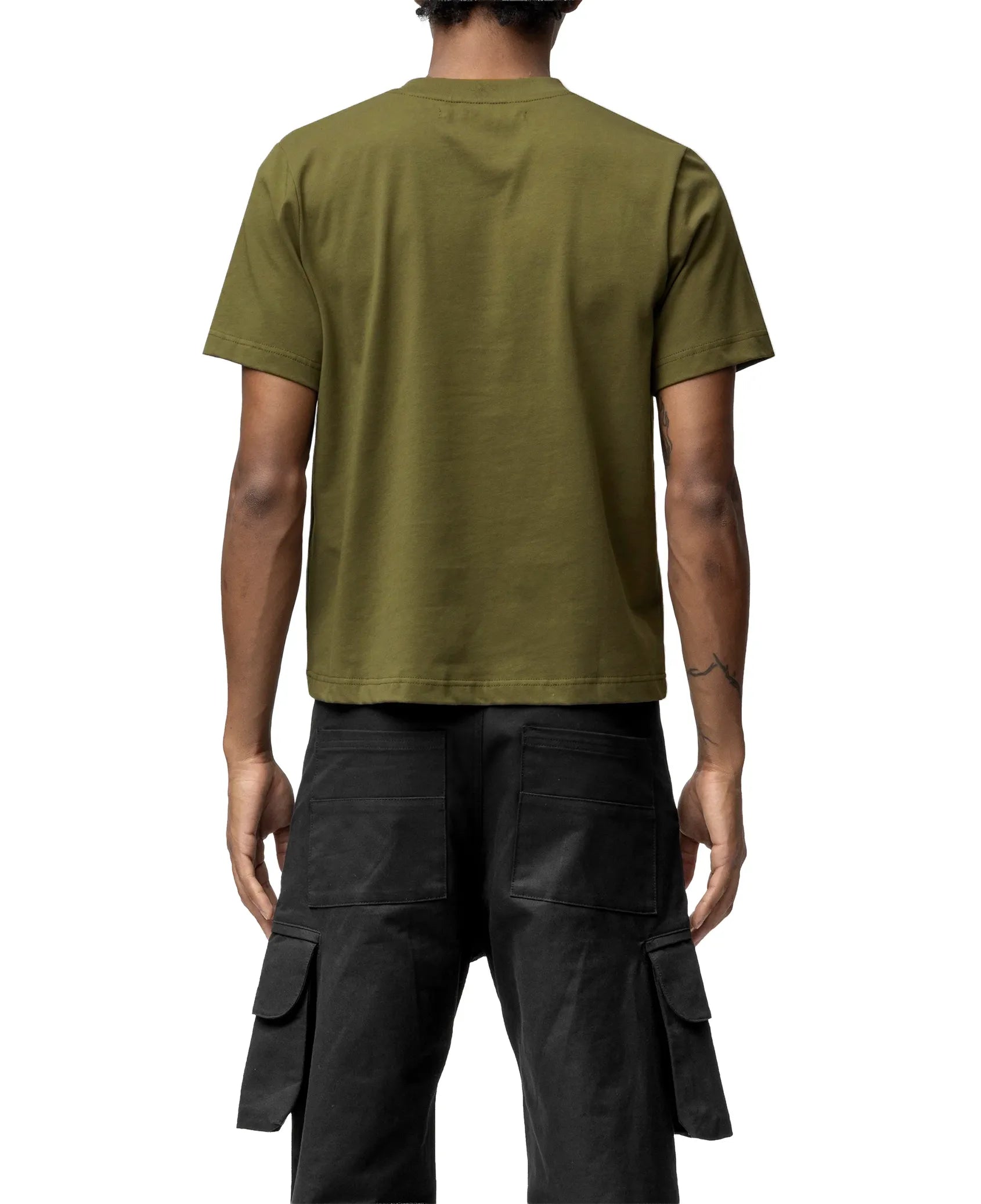 Person wearing an olive green t-shirt and black cargo pants on a white background