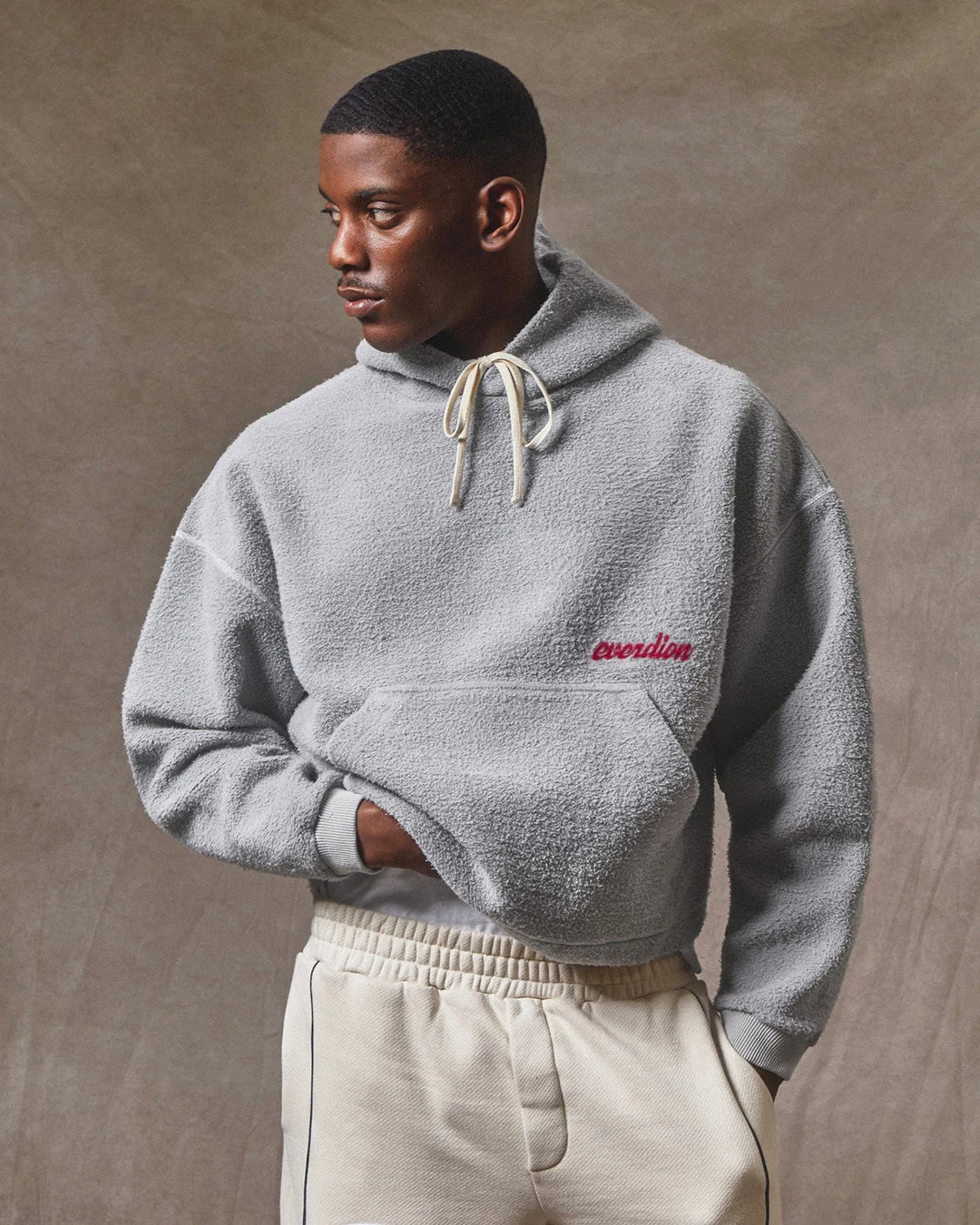 Person wearing a gray hoodie with 'everdion' branding against a neutral background