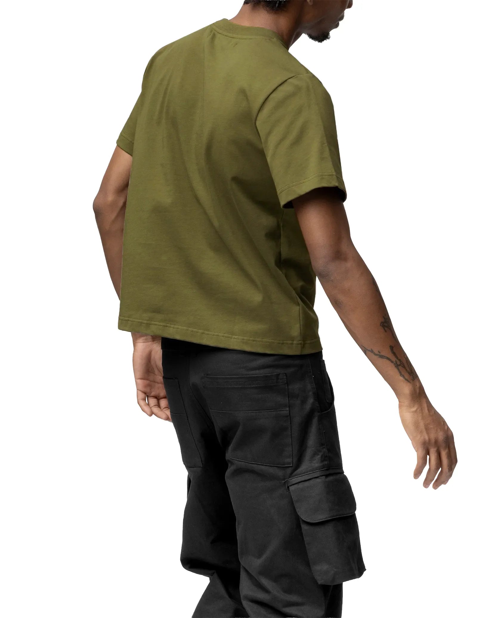 Person wearing an olive green t-shirt and black cargo pants on a white background