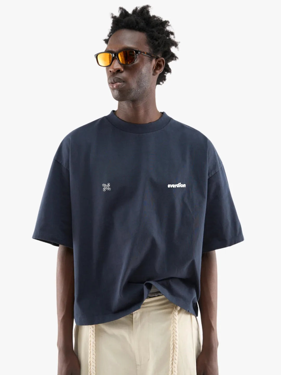 Person wearing a navy blue t-shirt with white text and graphics, standing against a plain background.