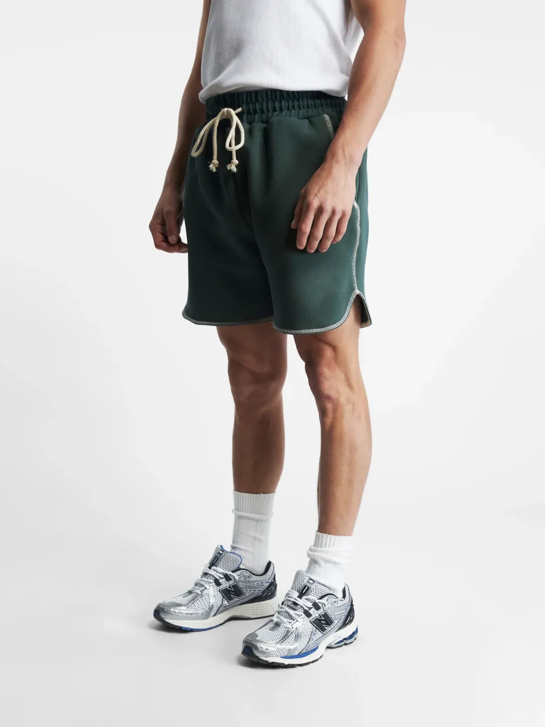 Person wearing green running shorts with a white background