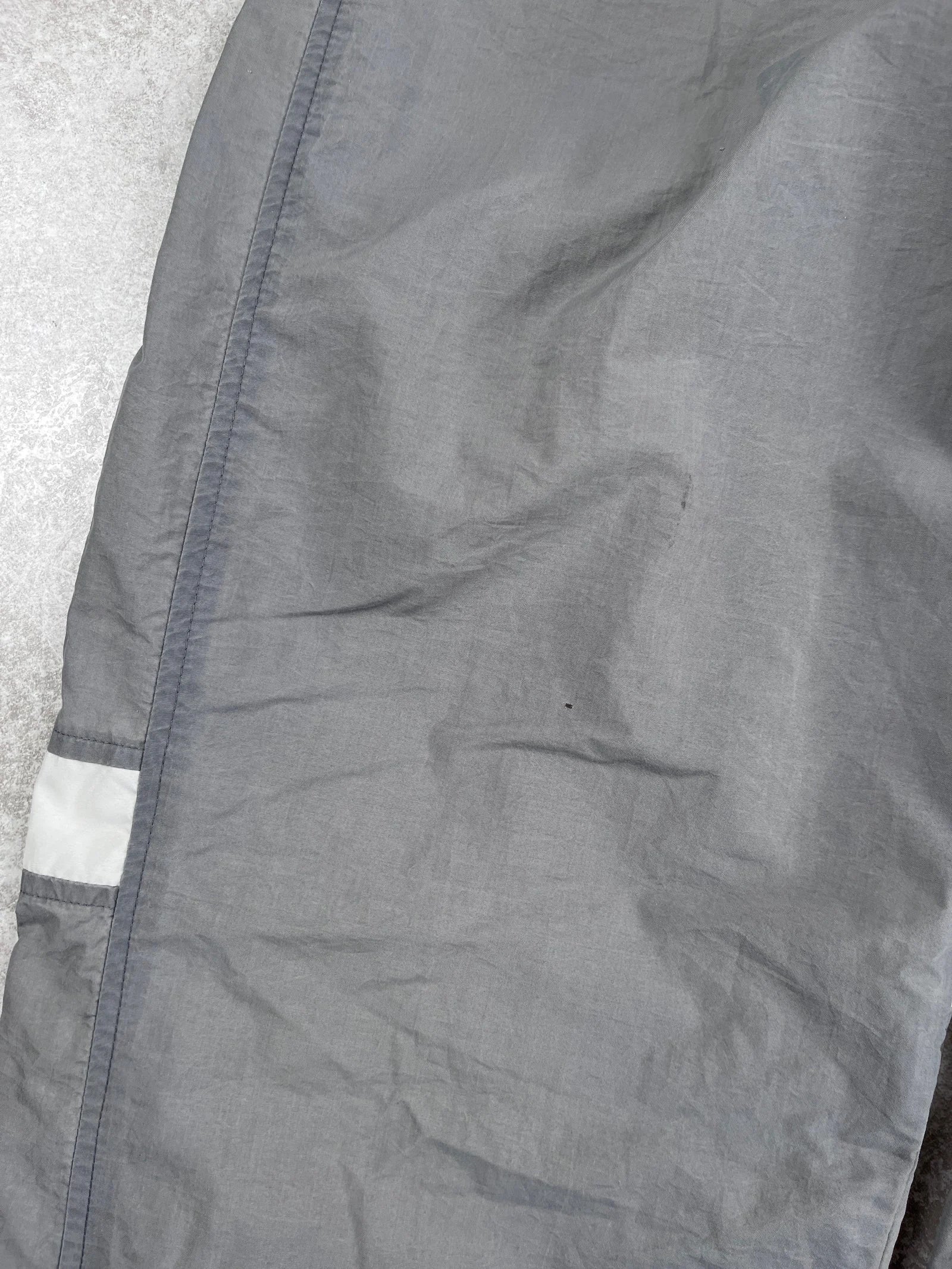 Close-up of a grey jacket with a reflective strip on a textured surface