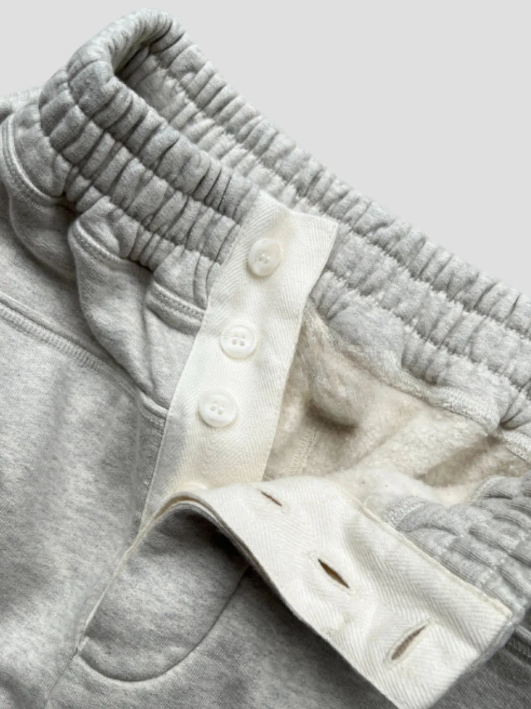 Person wearing button up grey sweatpants 