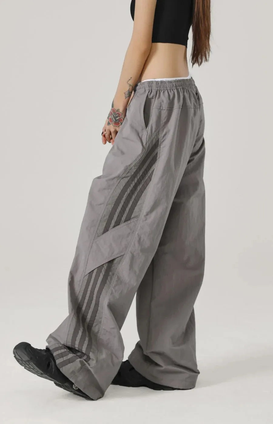 Person wearing grey wide-leg pants on a plain background