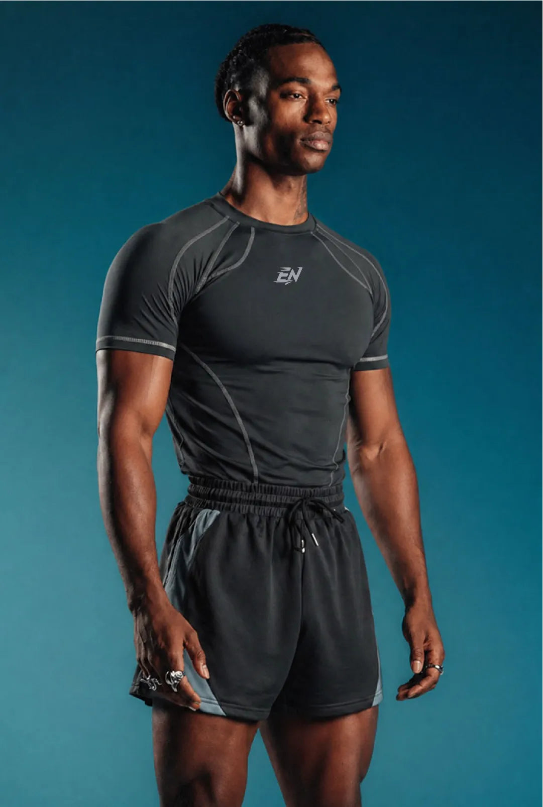 Man wearing a black athletic t-shirt with a brand logo on a blue background