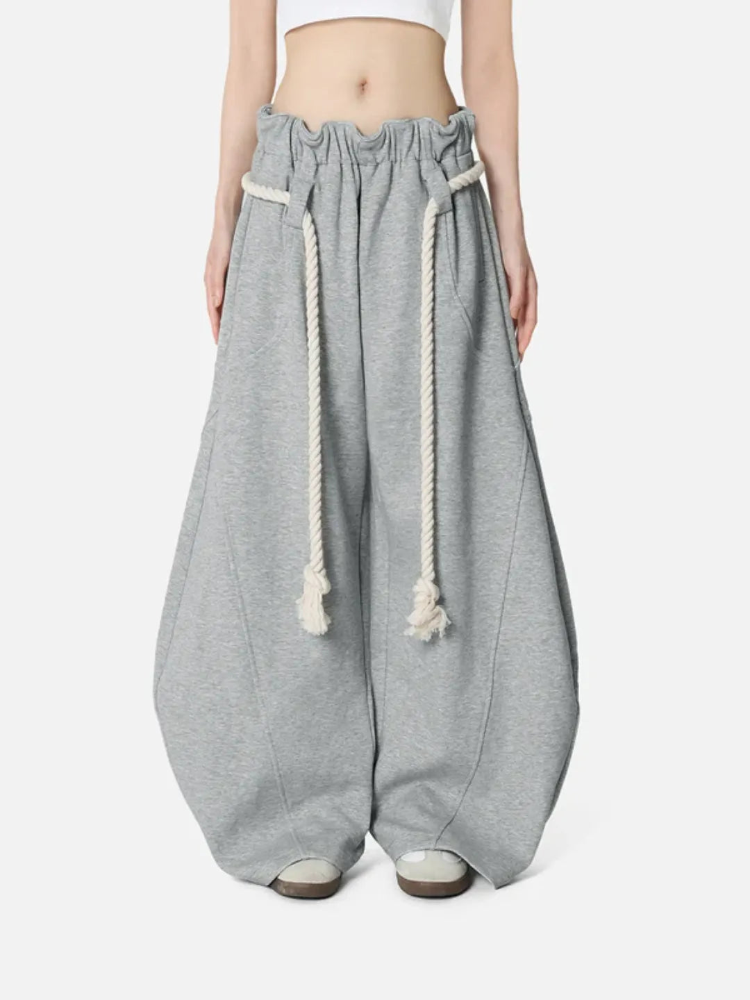 Grey baggy pants with drawstrings on a white background