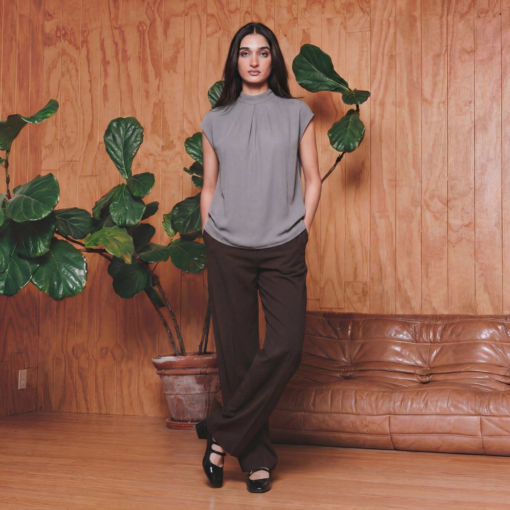 Woman in a grey work top and brown pants 