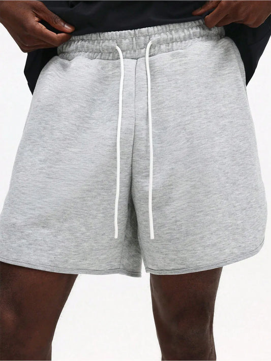 Grey shorts with white drawstring on a plain background