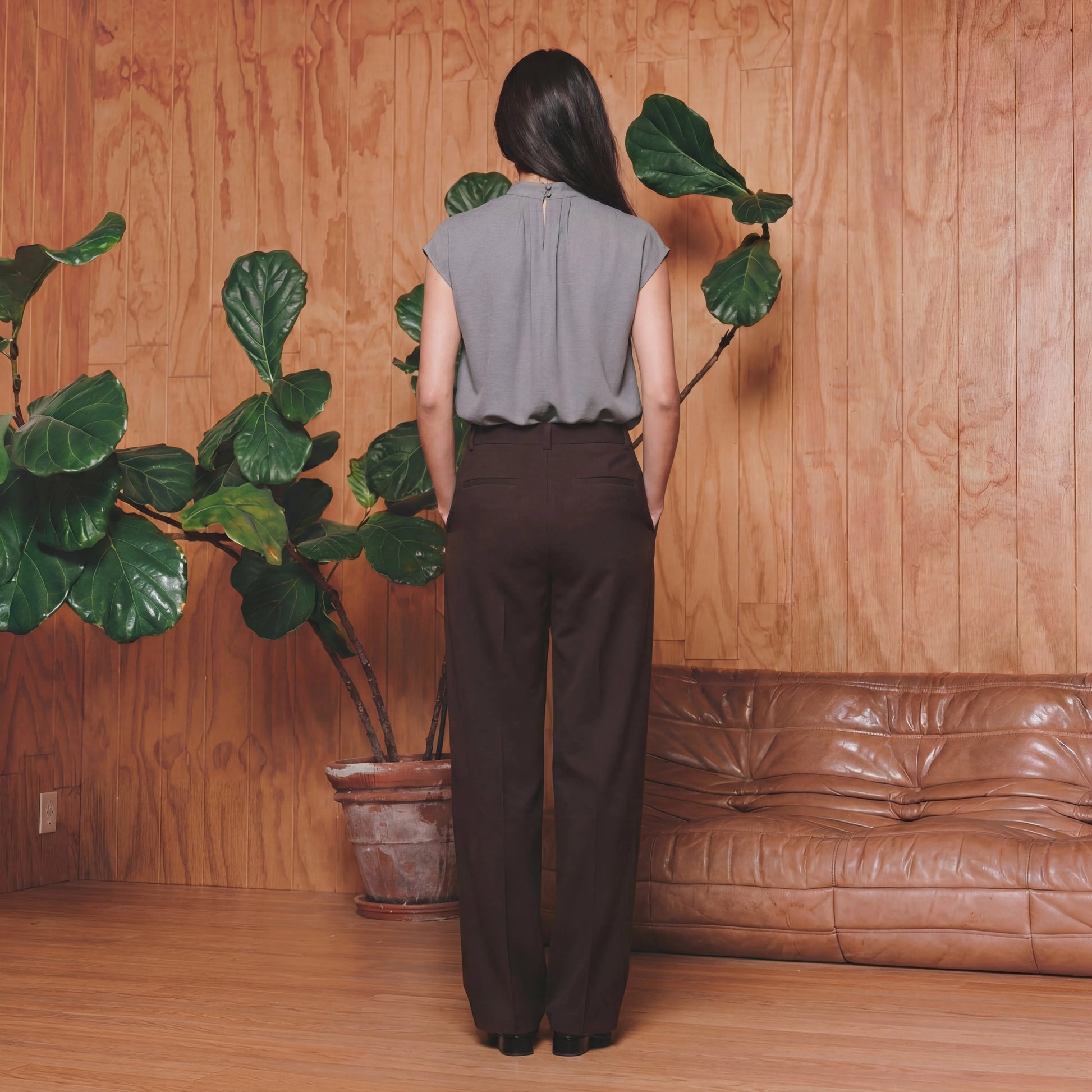 Woman in a grey work top and brown pants 