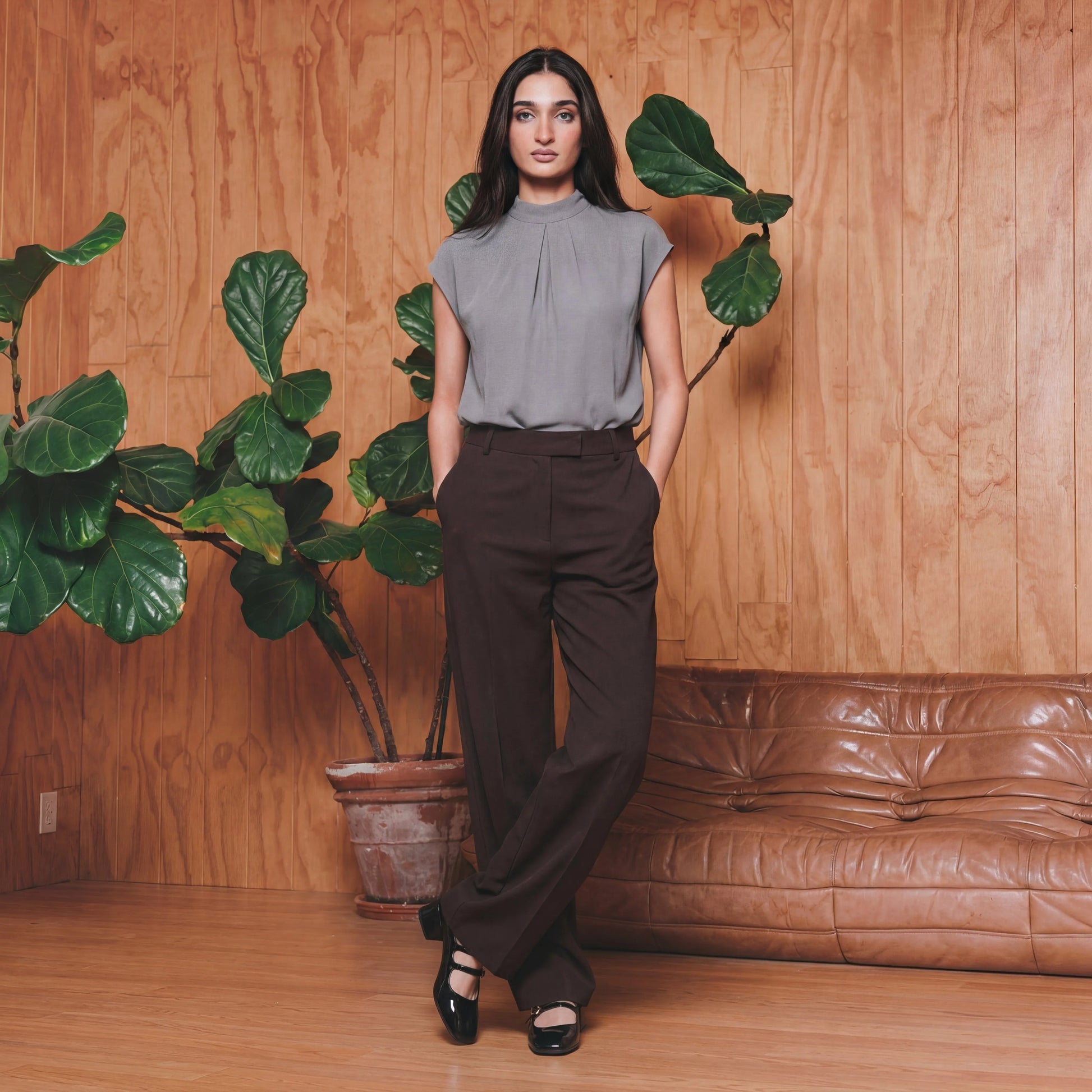 Woman in a grey work top and brown pants 