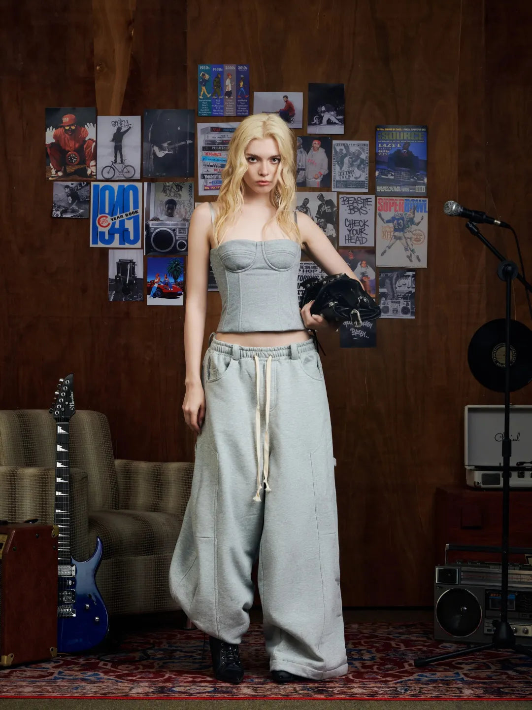 Woman in a room with posters on the wall and musical instruments.