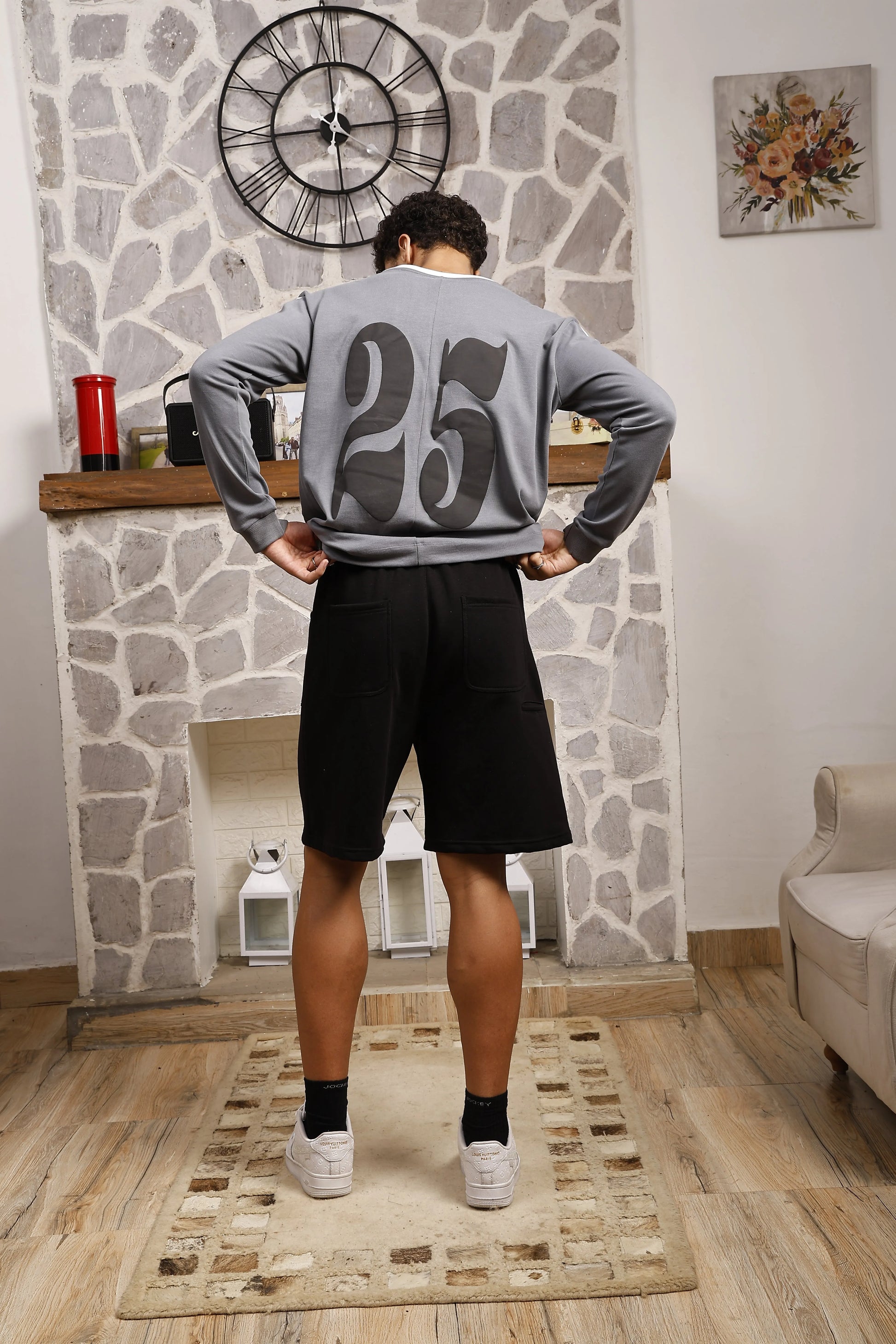 Person wearing a grey long sleeve sports t-shirt with '25' on the back 
