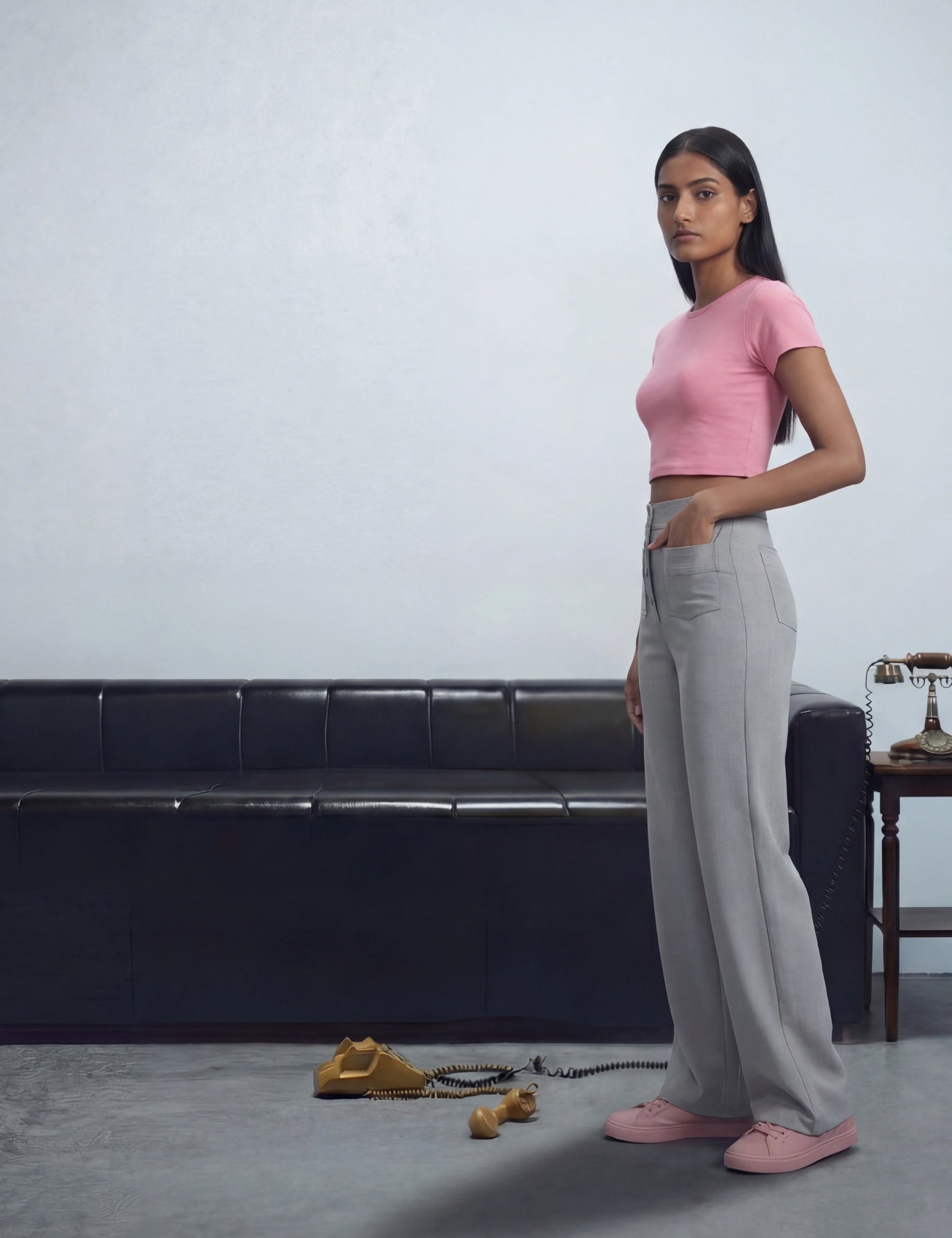 Woman in pink top and grey pants.