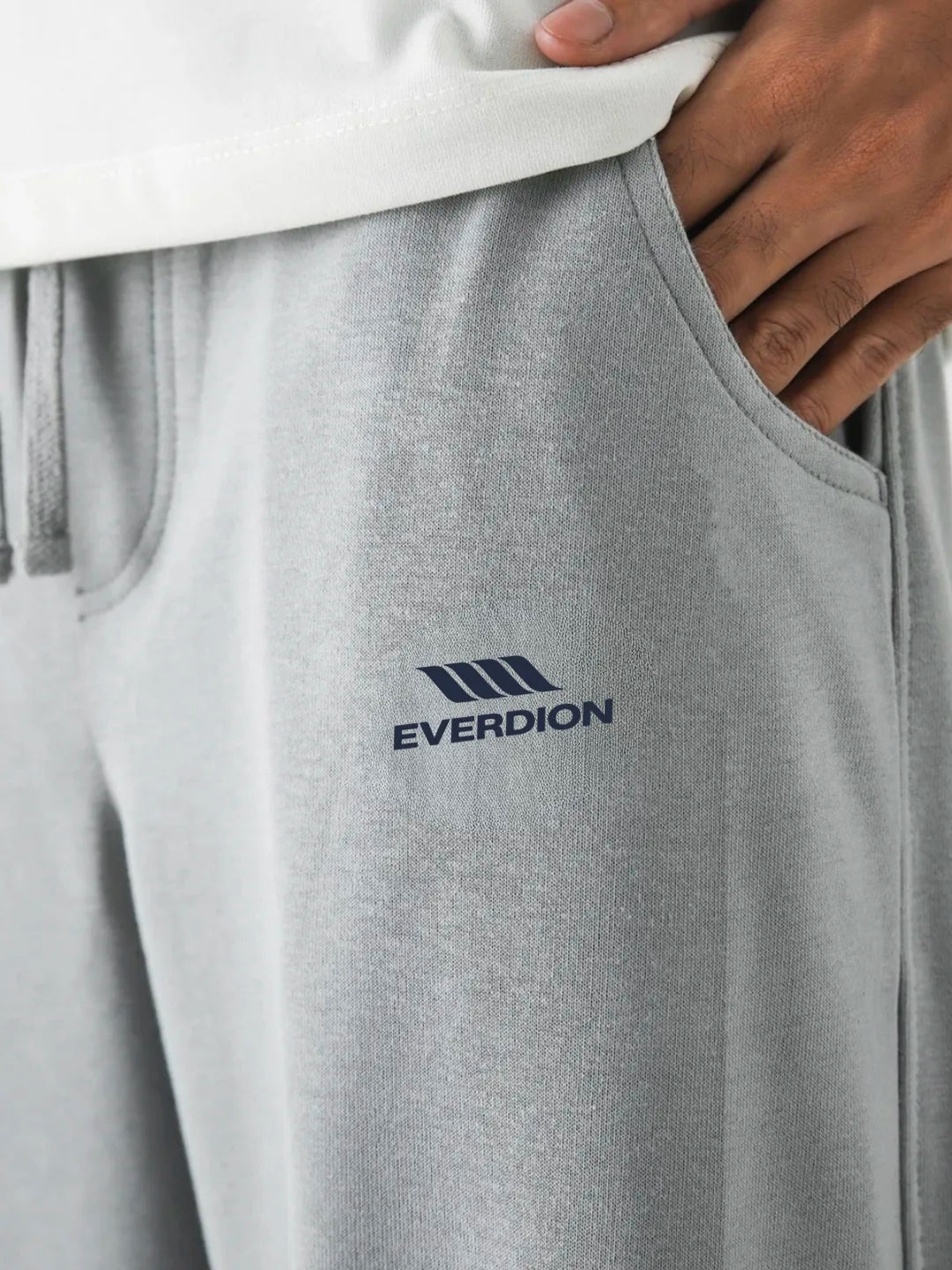 Grey sweatpants with 'Everdion' logo on a person wearing a white shirt.