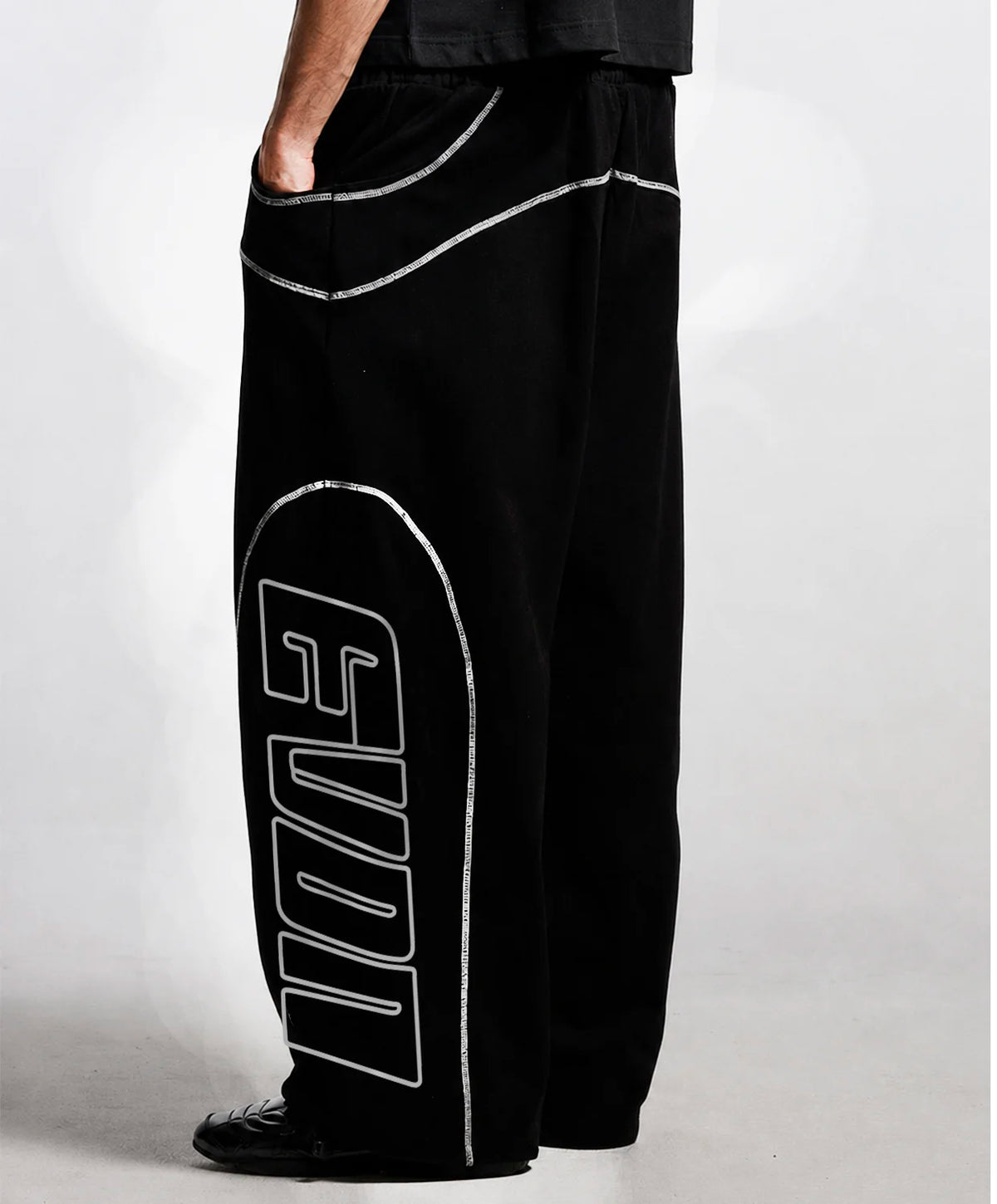 Black wide-leg sweatpants with a large white outlined 'EVON' graphic on the left leg