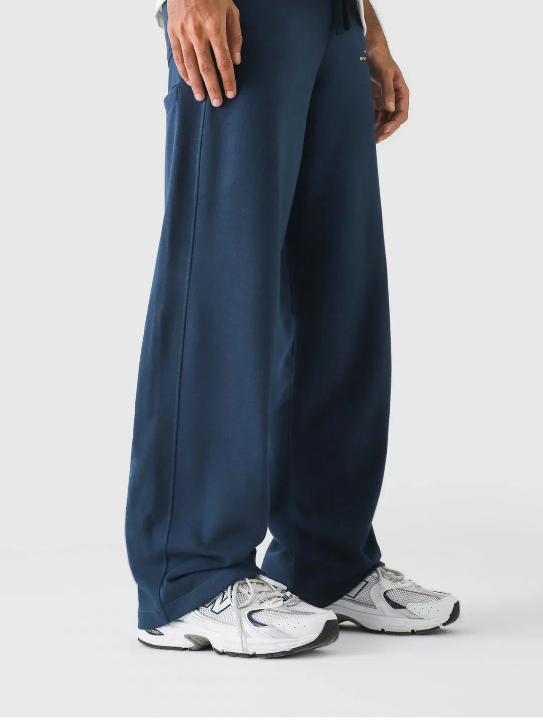 Navy blue pants worn by a person on a white background