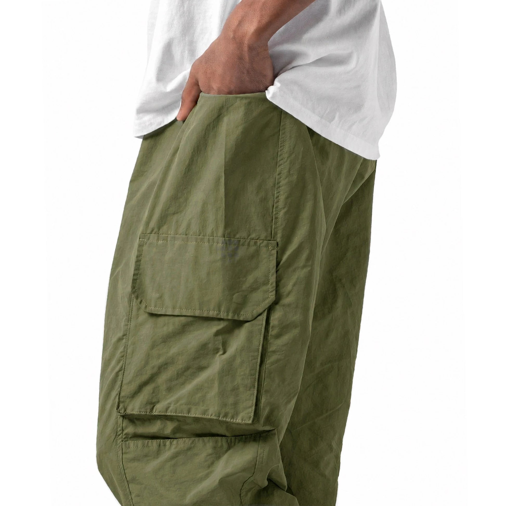 Green cargo pants worn with a white shirt on a white background