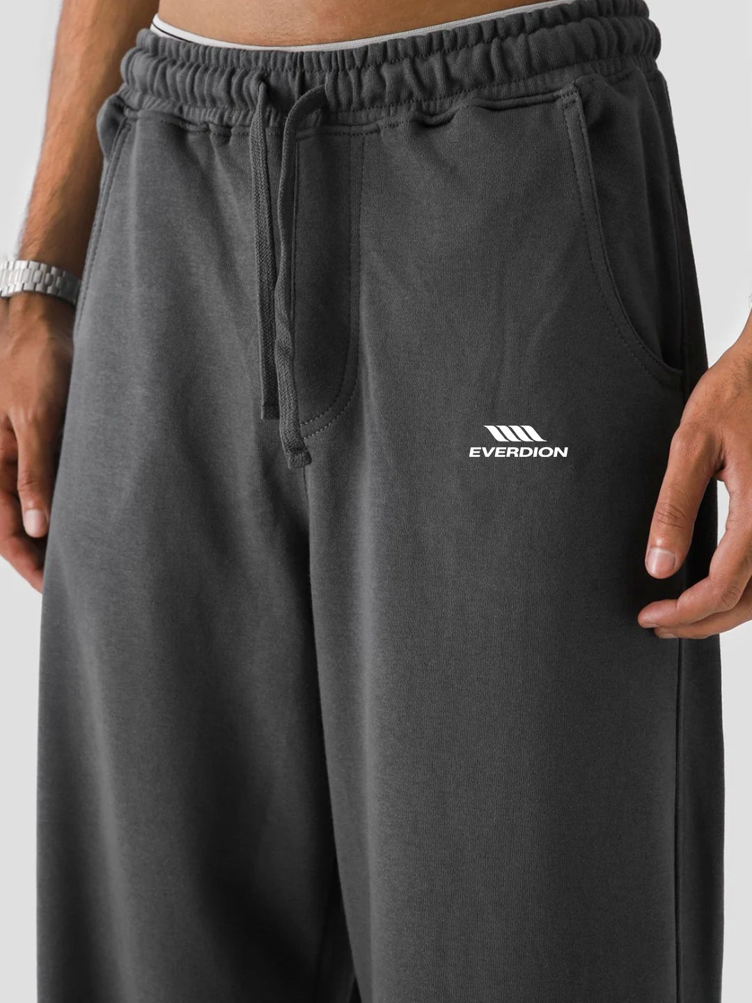 Dark grey sweatpants with a visible brand logo on a neutral background