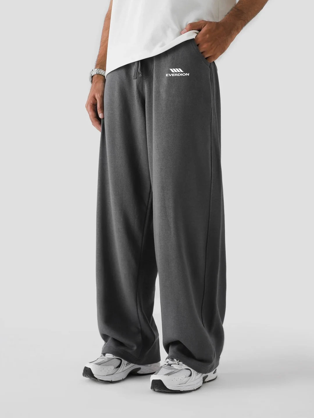 Person wearing grey sweatpants with a brand logo on a white background