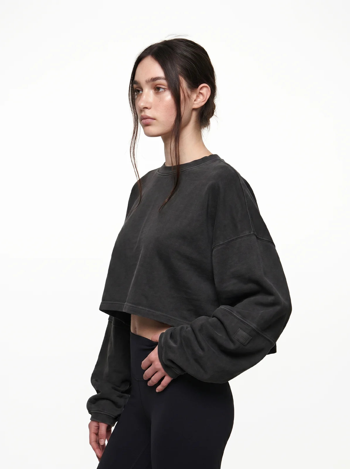 Woman wearing a black cropped t-shirt on a white background