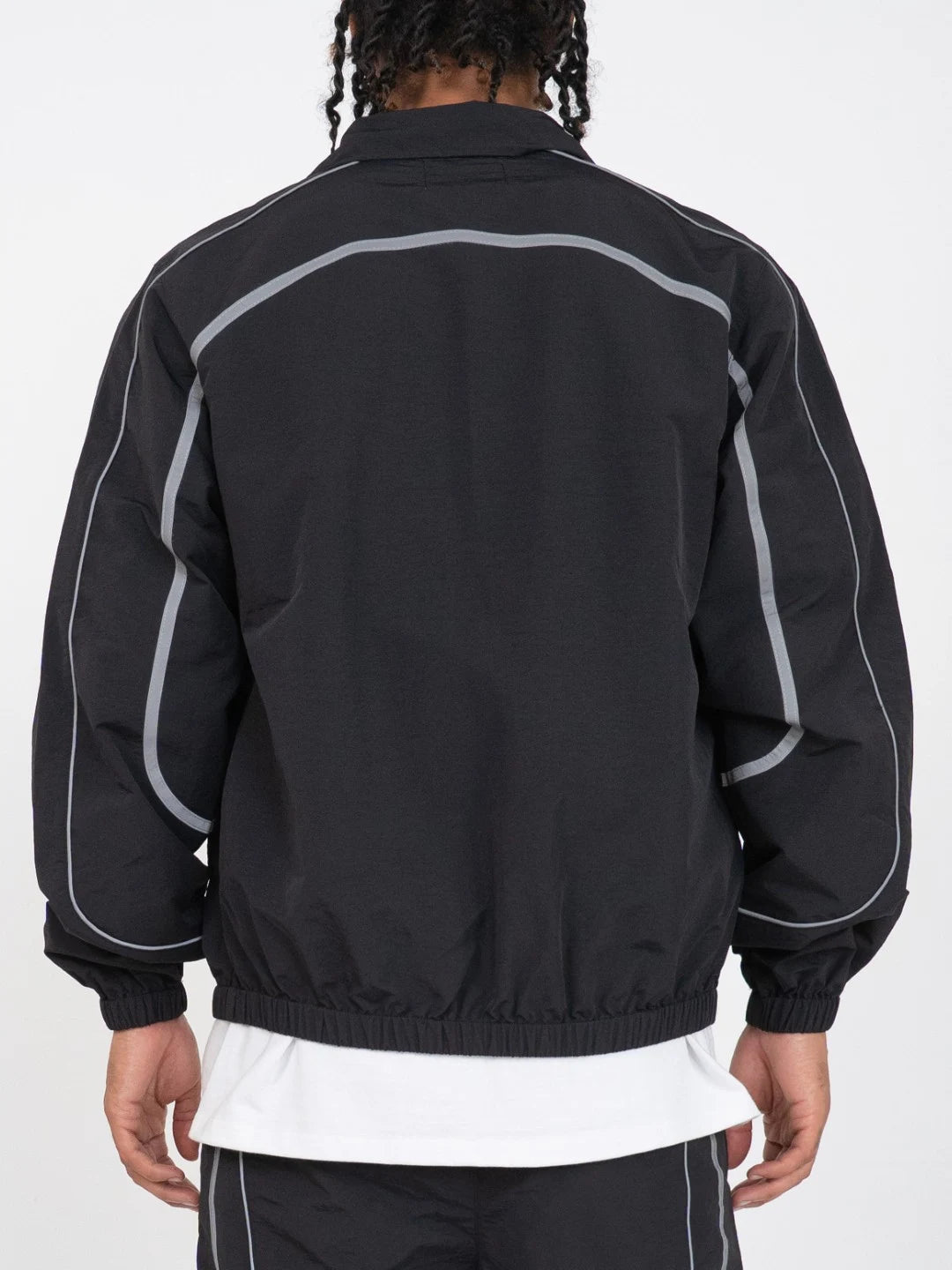 The Black jacket delivers a structured yet lightweight feel, while the relaxed-fit track pants ensure fluid movement and all-day comfort. 