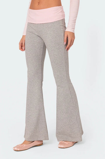 Grey flared pants worn by a person on a white background