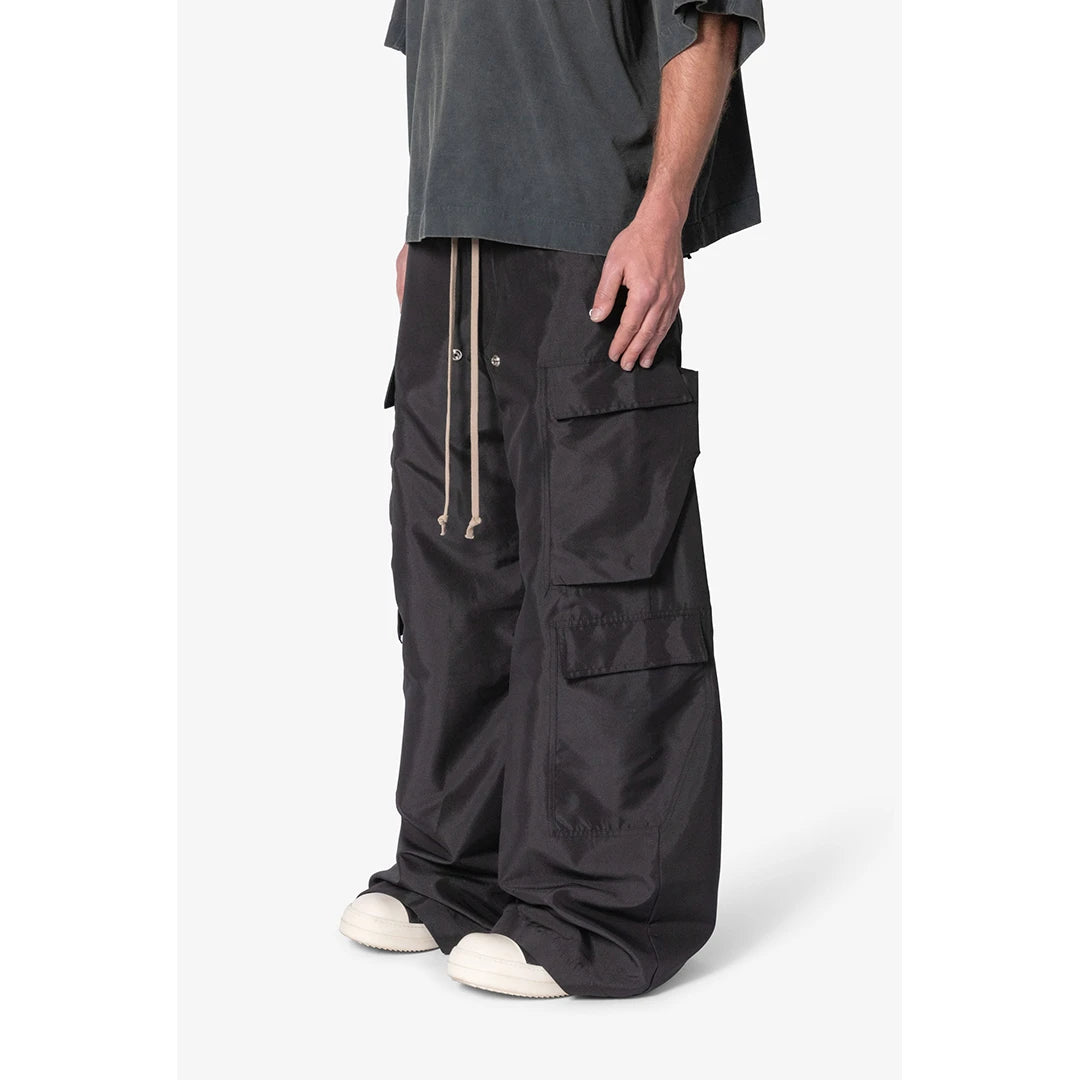 Person wearing black cargo pants on a white background