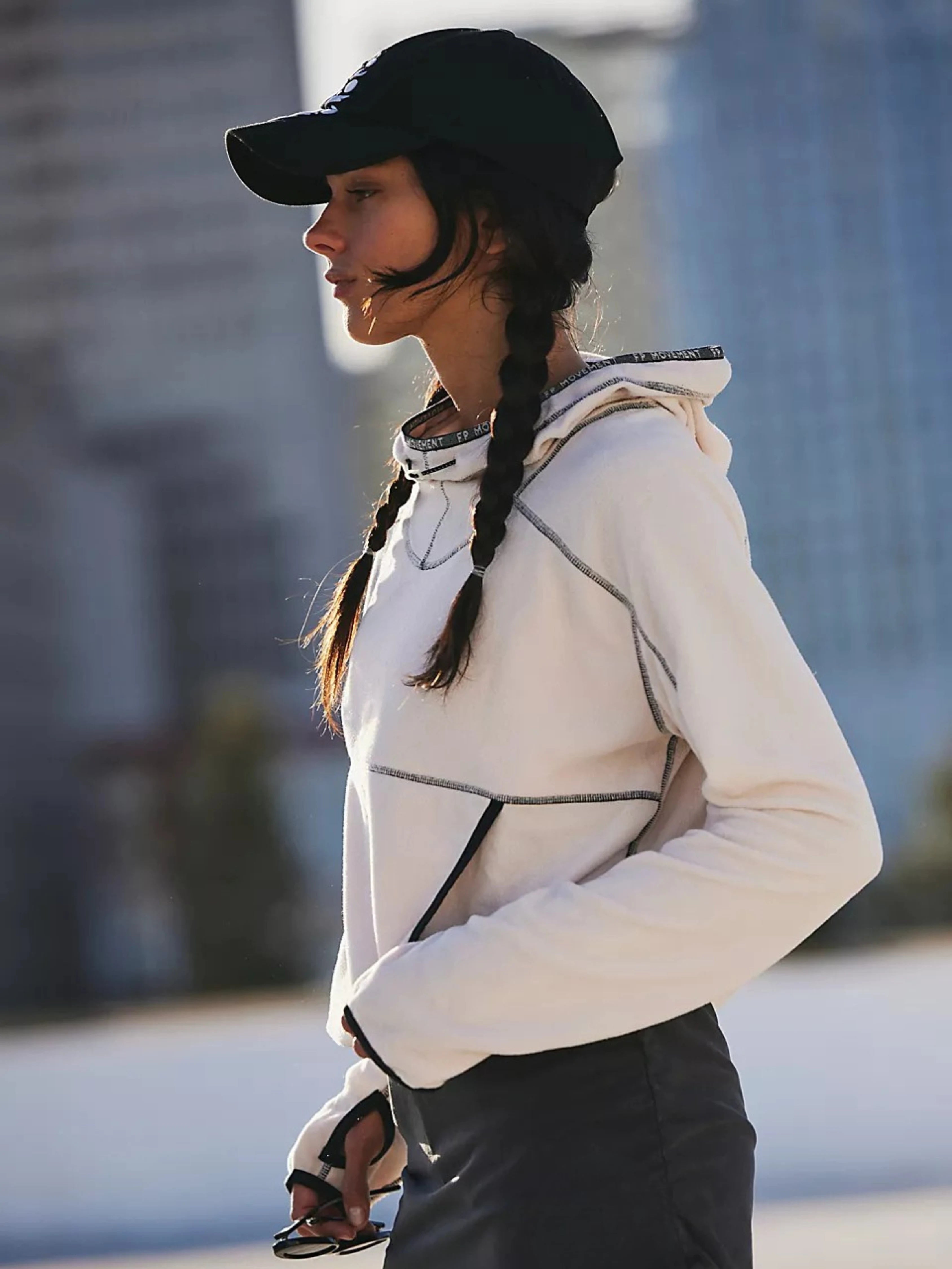 Woman wearing a white jacket and black cap outdoors